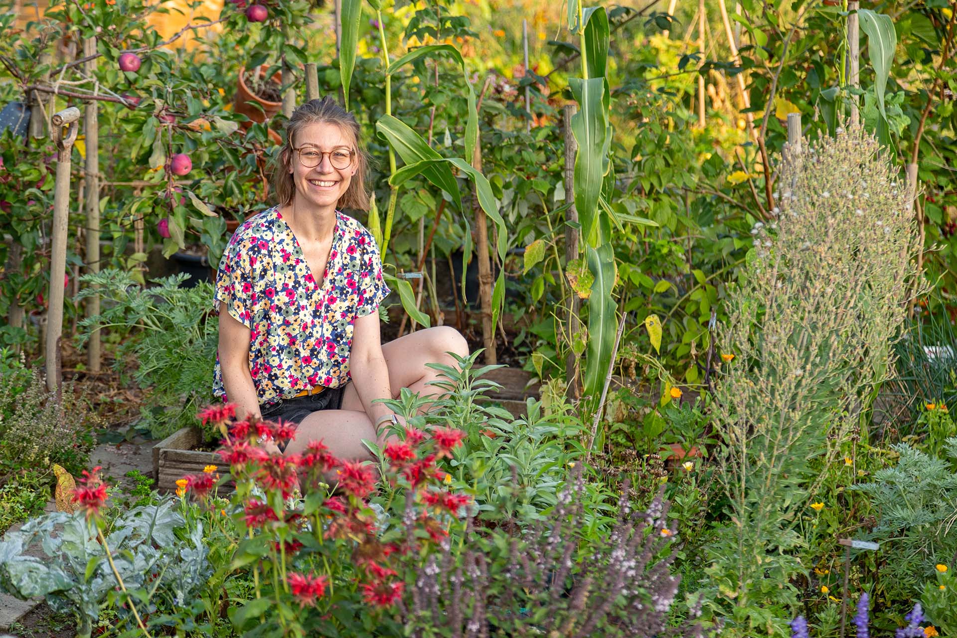 Martina in ihrem biodiversen Garten im VFD Familiengarten Areal Ifang in Dübendorf im August 2023.